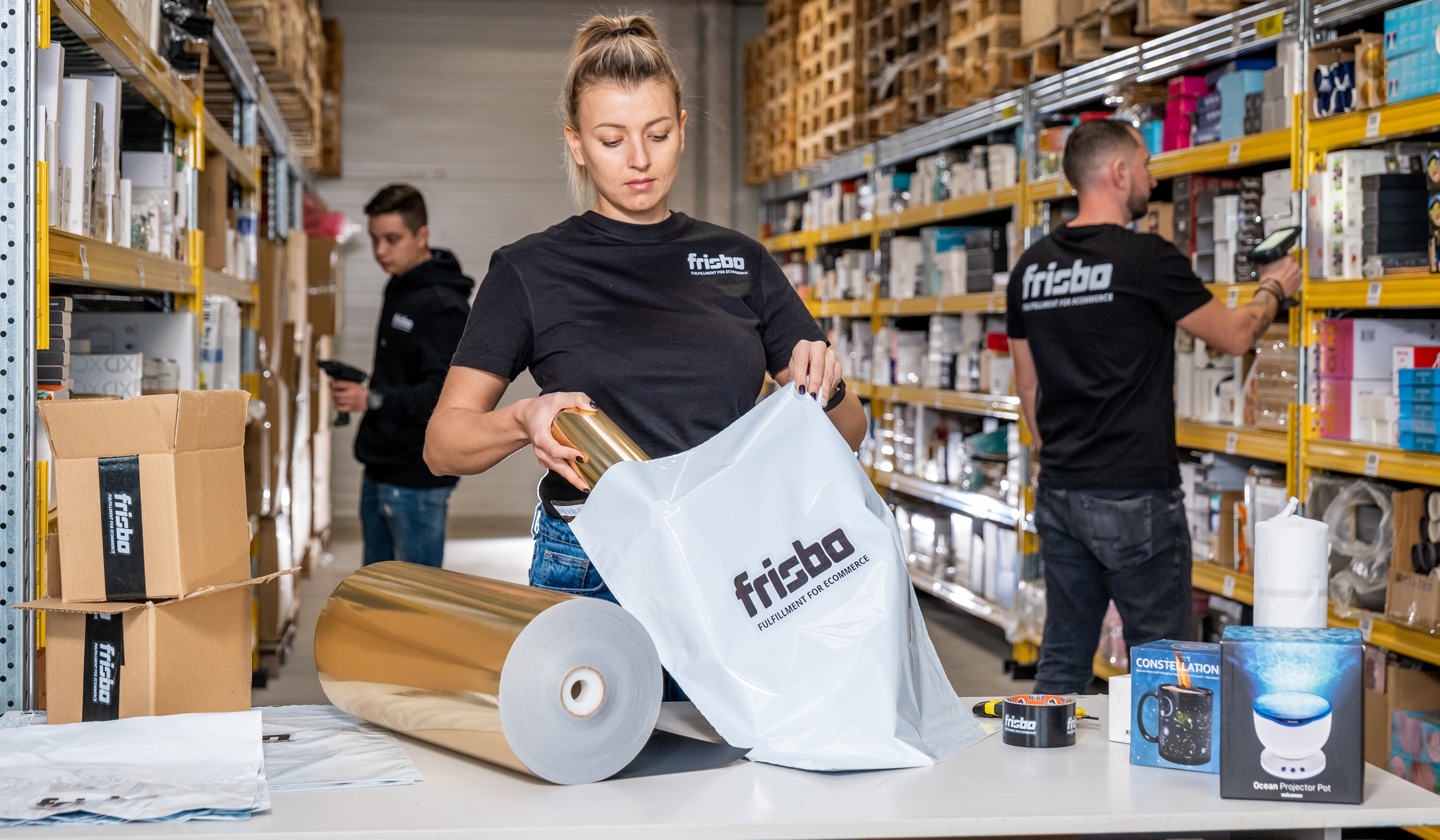 Girl packing up a product in a bag having the Frisbo logo on it