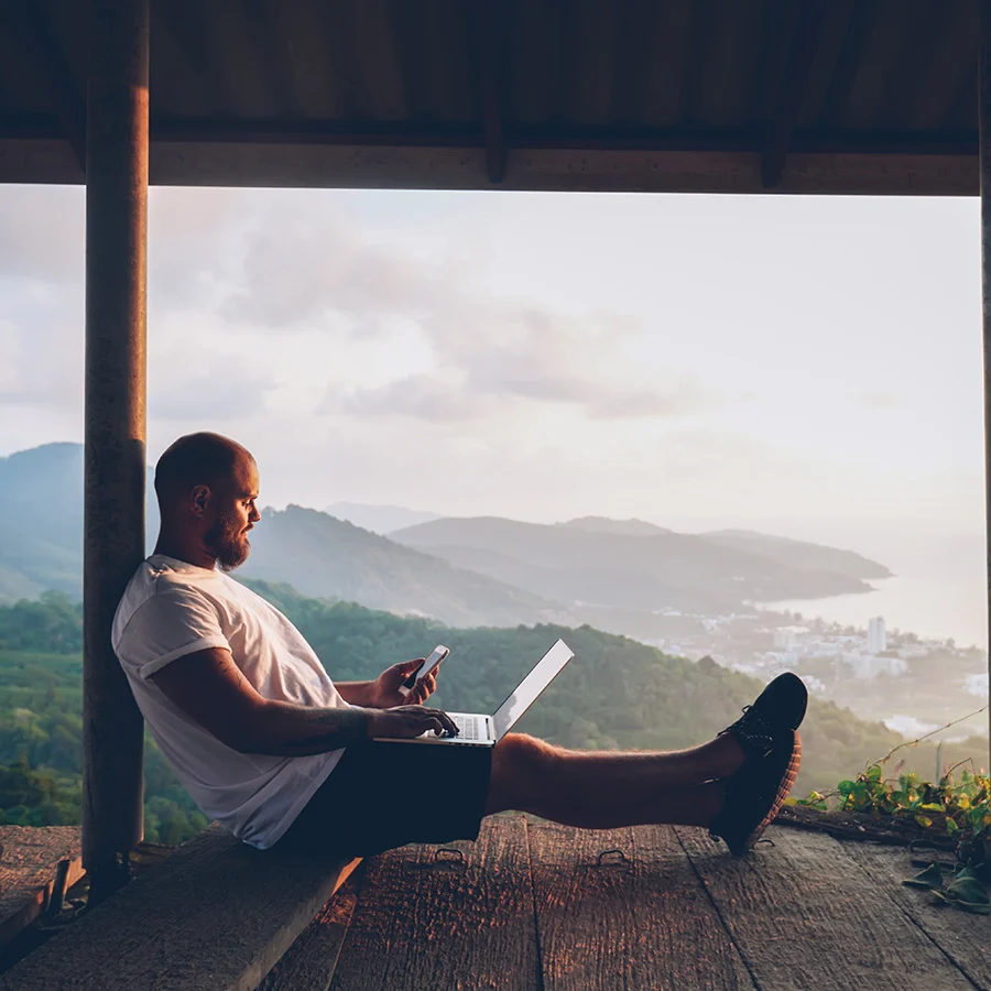 Person working with laptop in a scenic mountain view